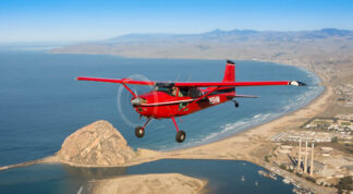 Cessna_180_Skywagon_flying_over_bay